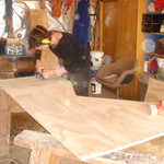 The expert sander showing Tom how it's done on the top of the desk.