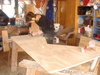 The expert sander showing Tom how it's done on the top of the desk.