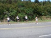 Anita handing off to Sarah, with two other B@stards looking on.
