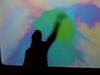 Tom making colour splatters on a digital screen at the decode exhibition, v&a museum.