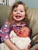 Iris cuddles her new sister.