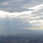 The sun, streaming through the clouds.